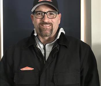 smiling bearded man with a black and green Servpro shirt on