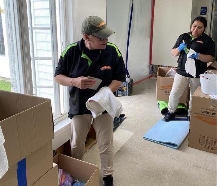 2 SERVPRO employees cleaning contents of a house