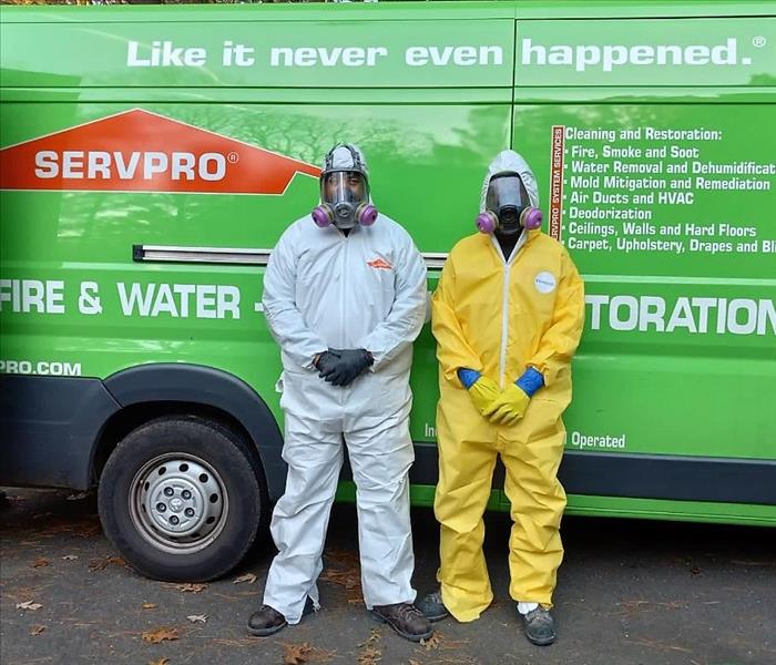 two servpro crew members dressed in biohazard protective clothing